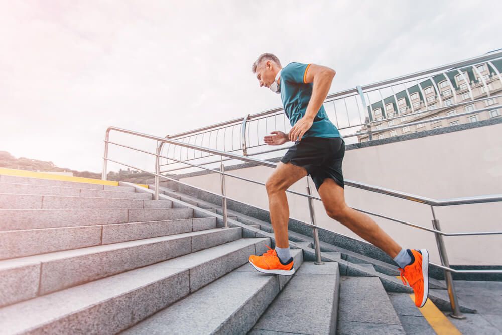 Healthy lifestyle middle aged man runner running upstairs