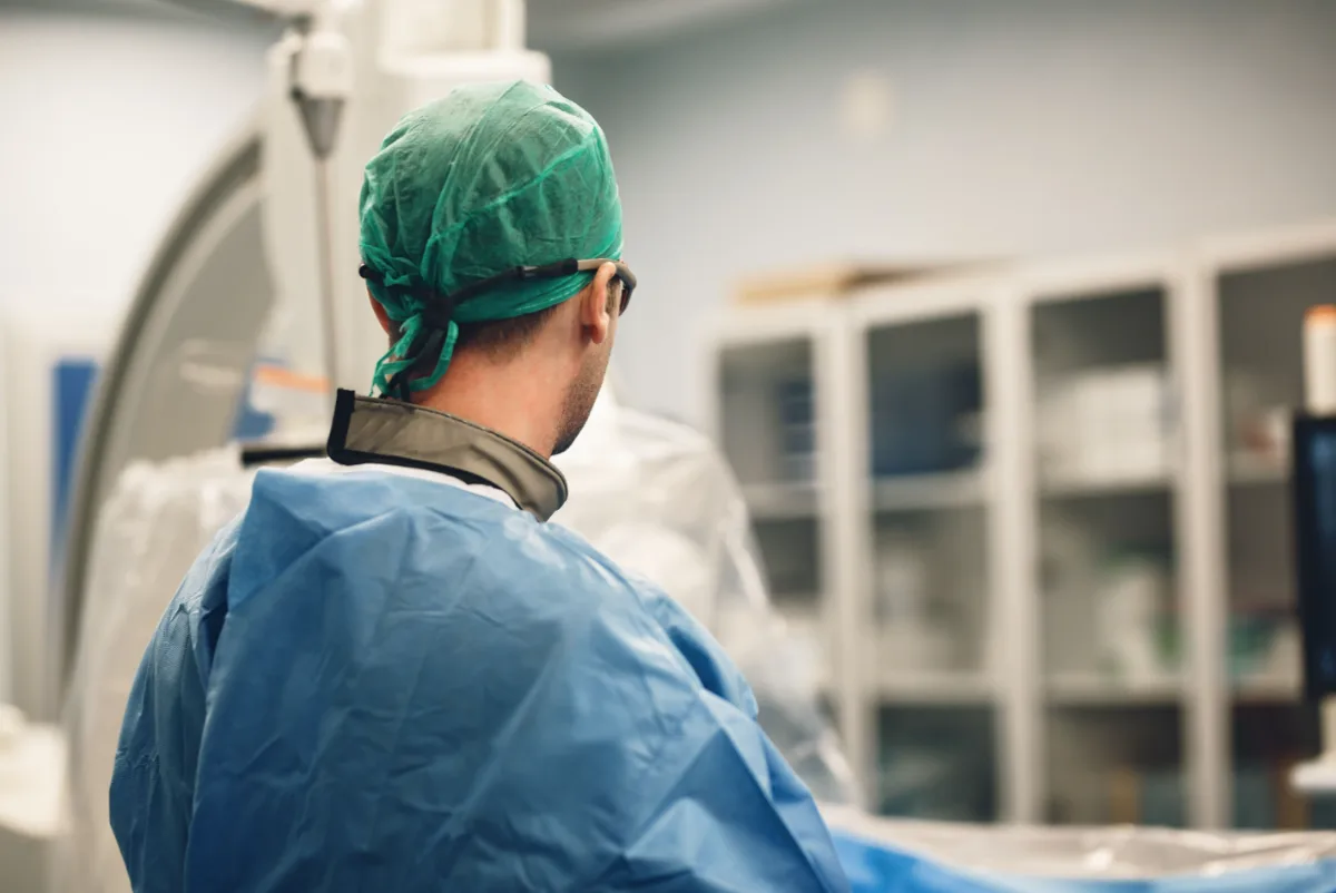 Surgeon in cap and gown in a procedure room
