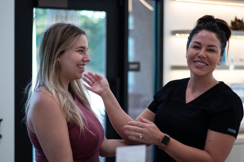 An estheticians and client smiling after a facial in the iO Clinic