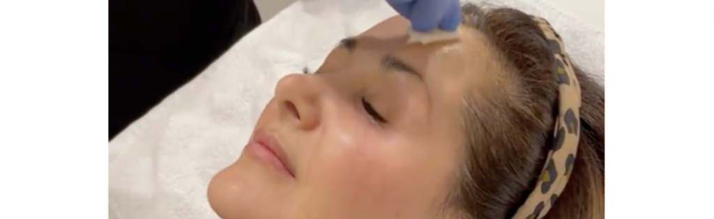 Premanent eyeliner on eyelids for young woman in beauty clinic
