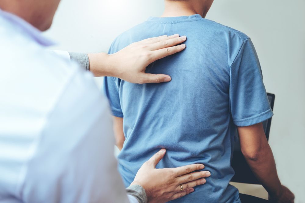 Doctor Consulting With Patient Back Problems