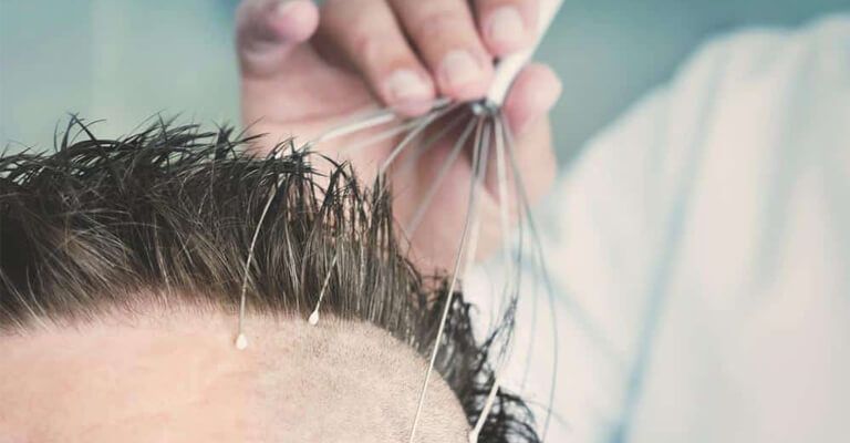 Male barber doing massage using capillary head massager of a man