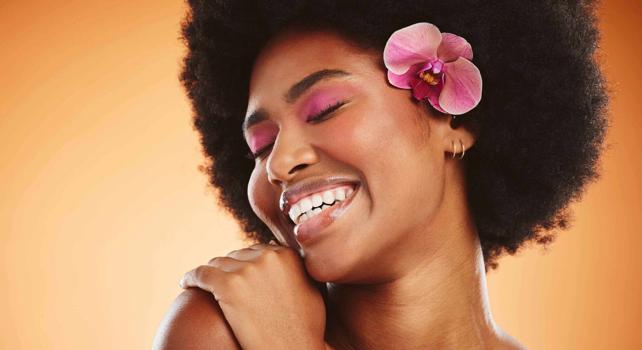 woman with an orchid looking happy