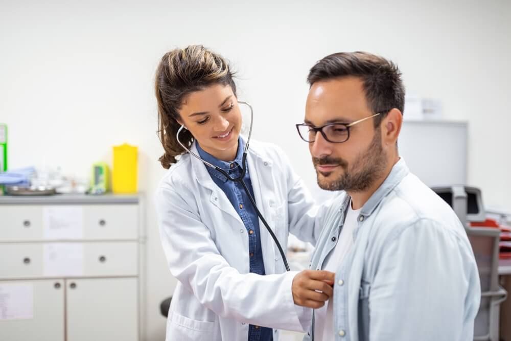 Young doctor is using a stethoscope listen to the heartbeat of the patient