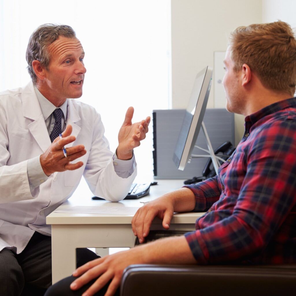 Patient Having Consultation With Male Doctor In Office