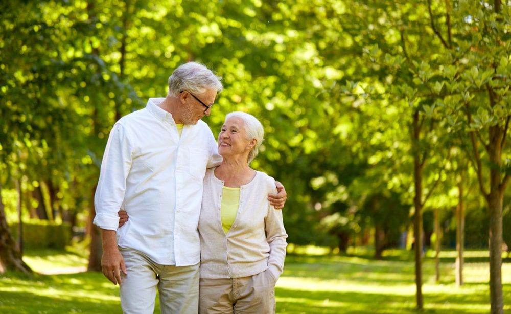 happy senior couple hugging in city park