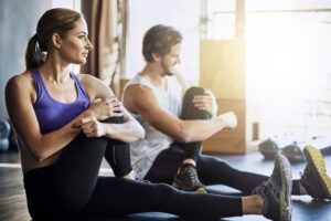 Warming up before their workout. Shot of two young people warming up before their workout.