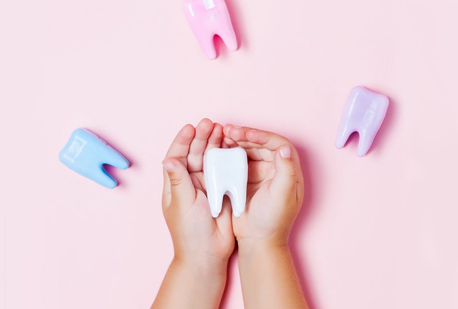 Child's hands holding big tooth