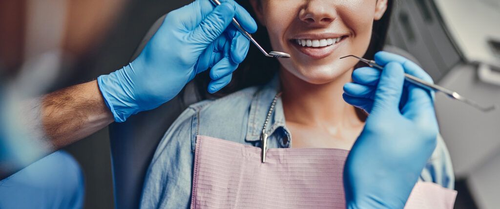 Attractive young woman in stomatology clinic with dentist