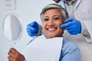 Happy senior woman smiling in dental clinic