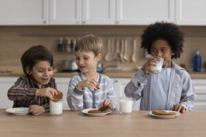 Happy boys keeping healthy nutrition, getting calcium from dairy products