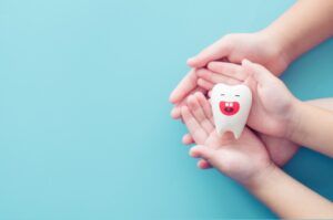 Teeth smile on children hands.Clean treatment Ename