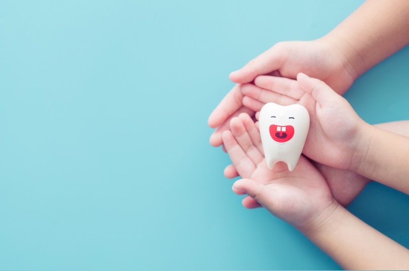Teeth smile on children hands.Clean treatment Ename