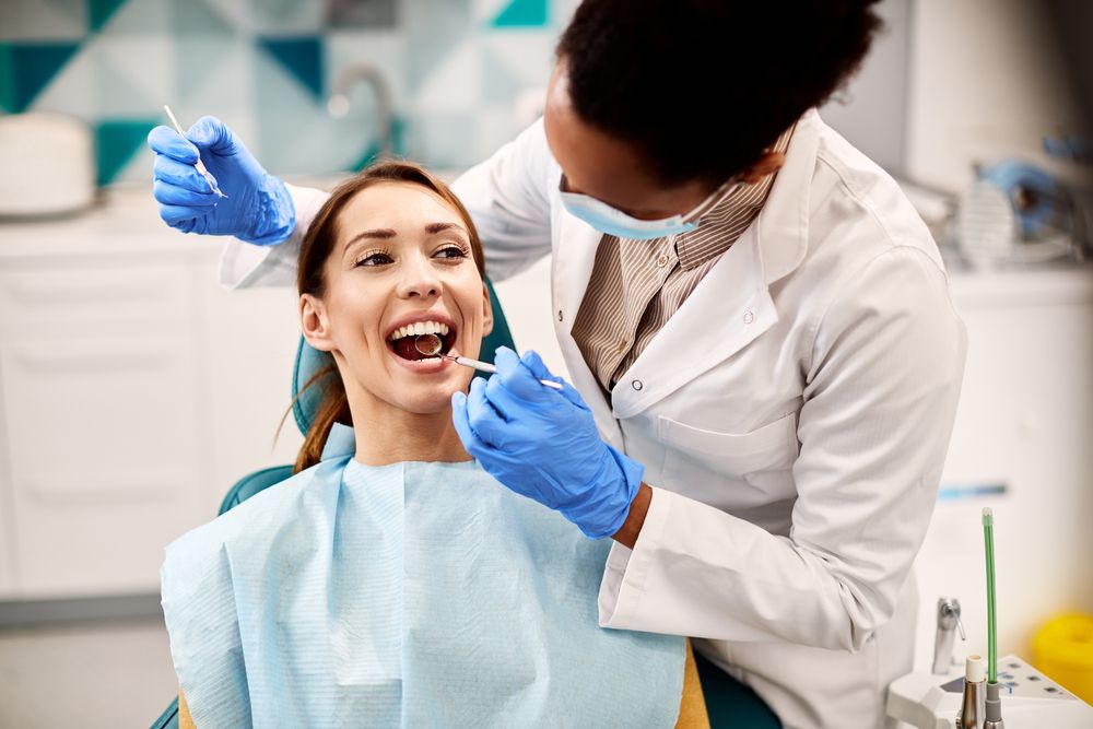 Young smiling woman having her teeth checked by dentist