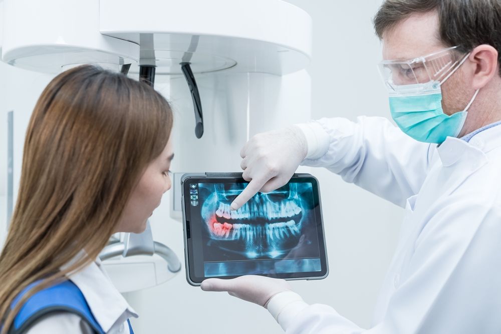 male dentist hold digital tablet and explaining tooth problem