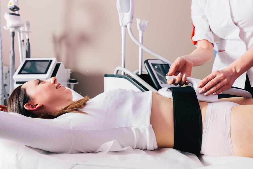 Woman getting treatment on abdomen to burn fat