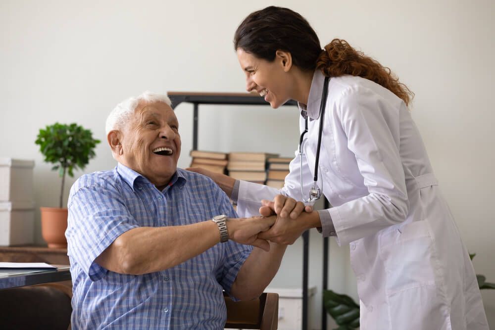 physician with elderly patient offering geriatric care