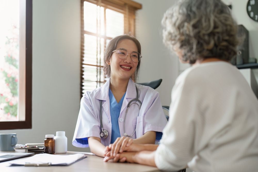 Female primary care physician having conversation with older woman