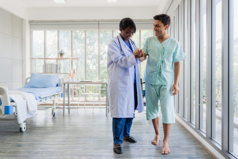 A successful recovery story: a happy patient walks again, holding his doctor's hand for support and encouragement.