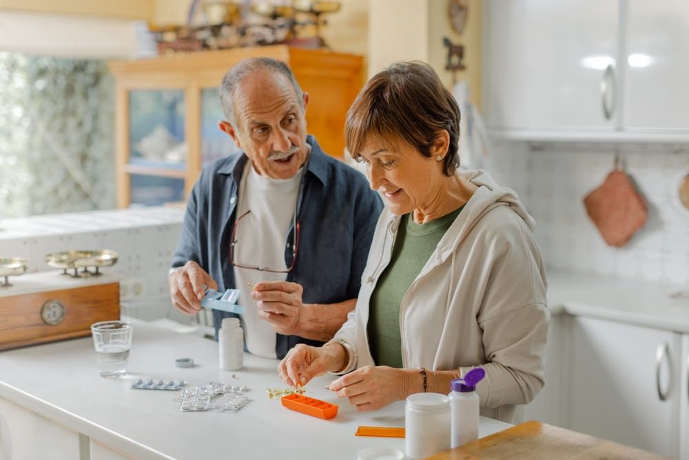 An elderly couple engages in a thoughtful discussion about medication management within a cozy kitchen setting