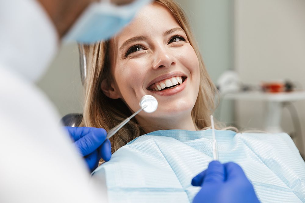 Pretty young woman sitting in dental chair at medical center