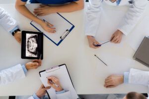 Group of doctors discussing jaw x-ray on tablet