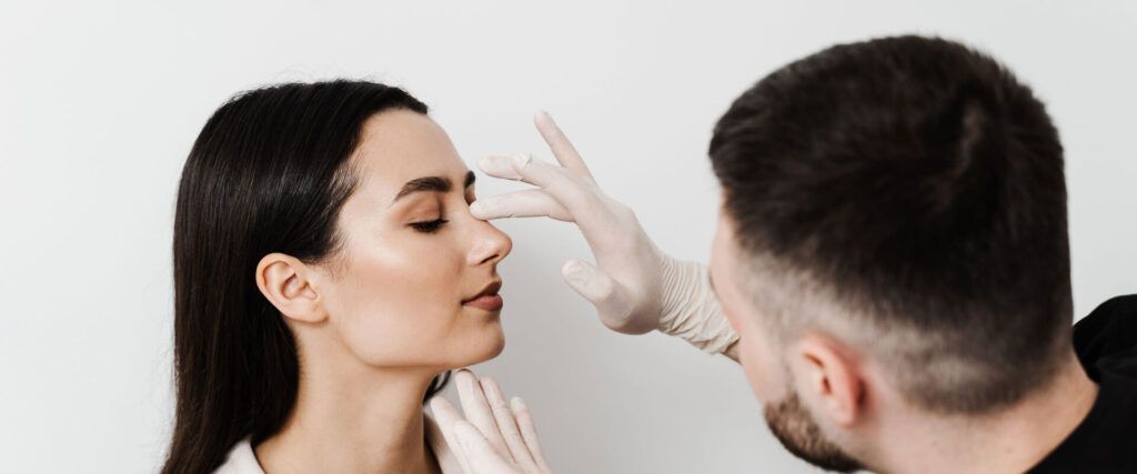 ENT doctor is touching nose and consulting girl patient