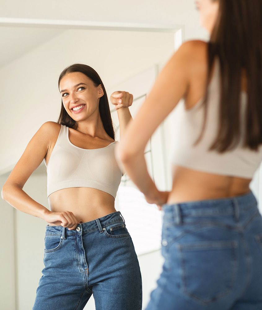 Happy lady pointing finger at her reflection in mirror