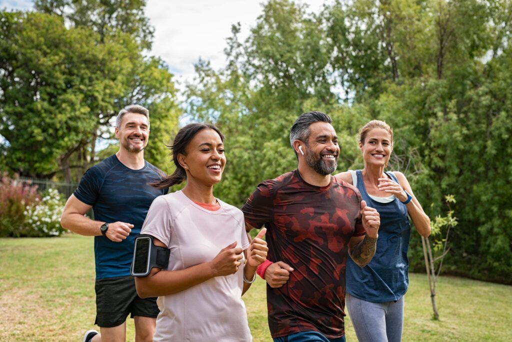 Healthy group of middle aged men and women jogging at park