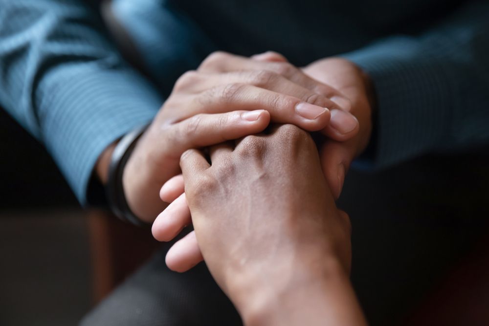 People holding hands going through Grief