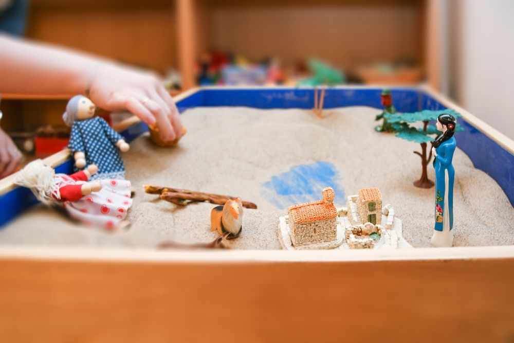 A person using sand during Sand Tray Therapy