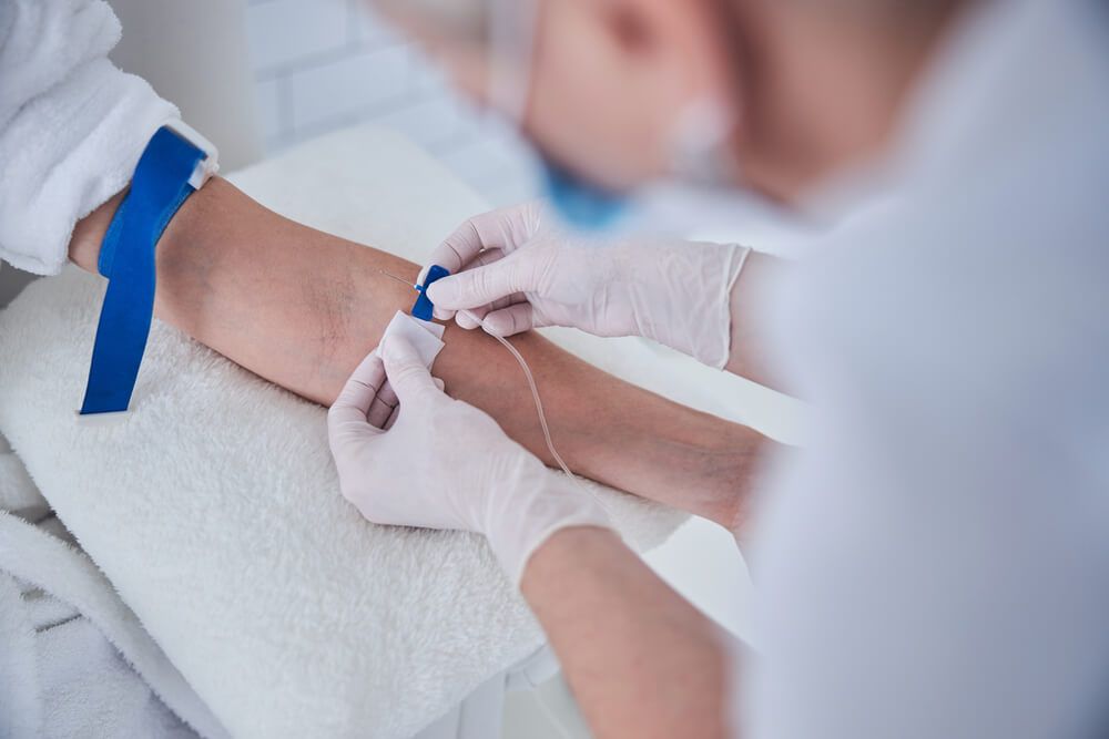 Female sitting in the cosmetic chair while receiving IV infusion