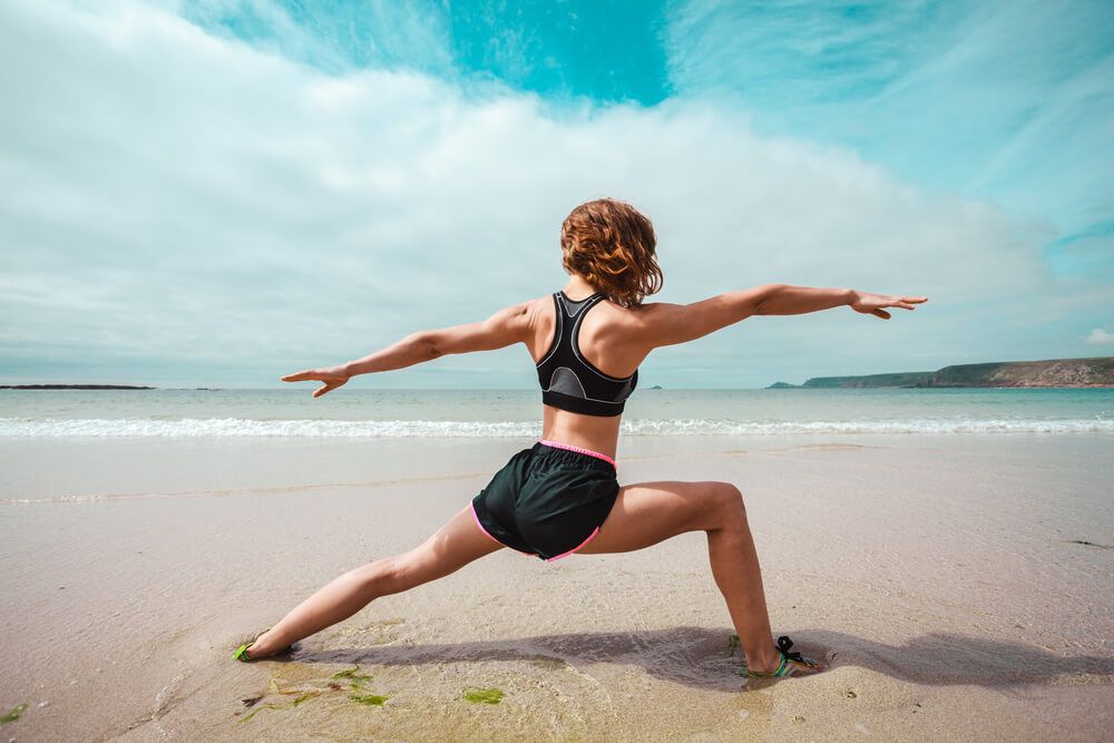 A young woman doing yoga on the beach