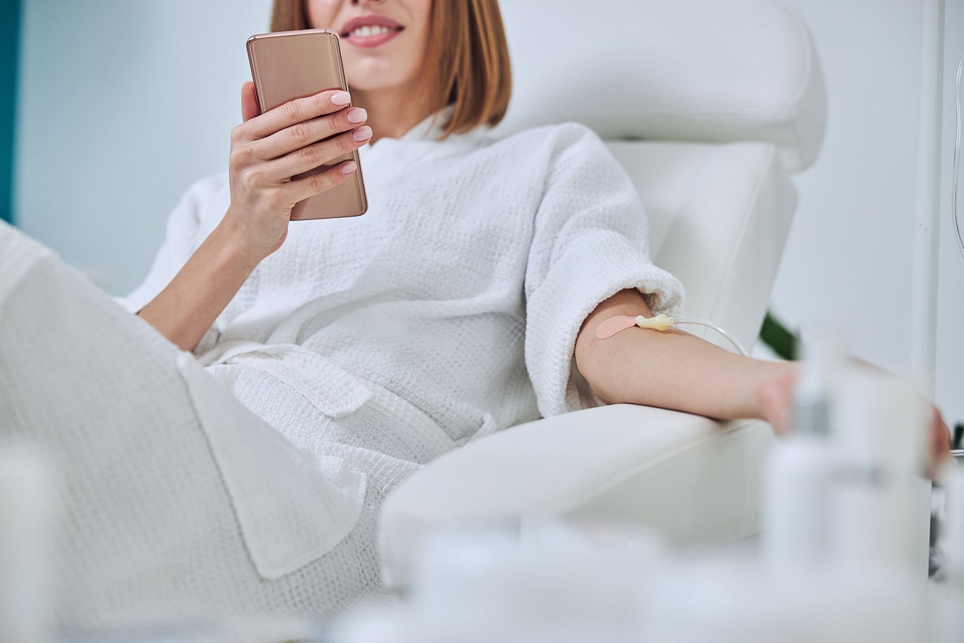 Beautiful woman sitting in armchair during medicine procedure in spa salon