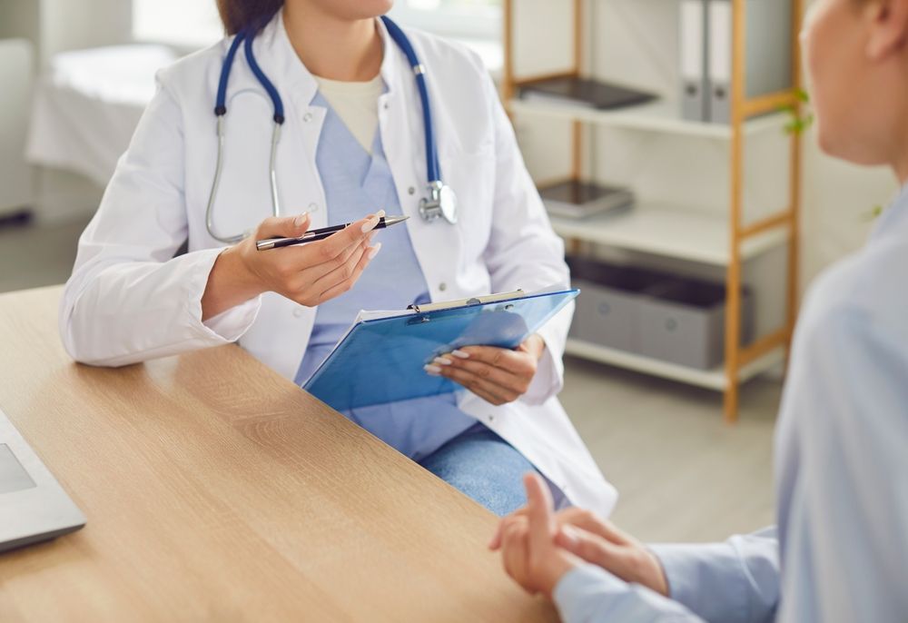 Close up shot of a doctor or nurse hands during a medical consultation and conversation with a patient in the hospital