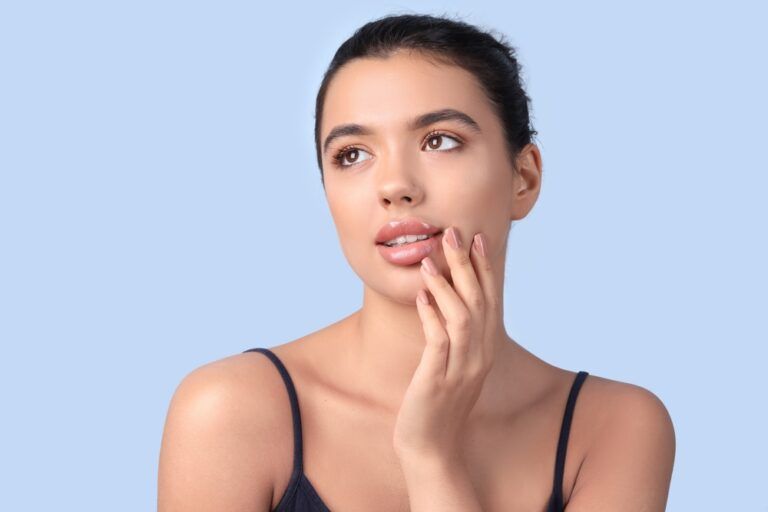Young woman with beautiful lips on blue background, closeup