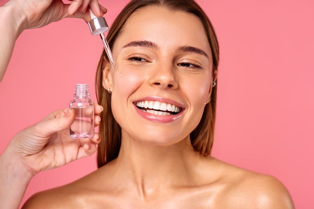 Beautiful woman face, natural clean and fresh glowing skin, applying anti-aging collagen serum