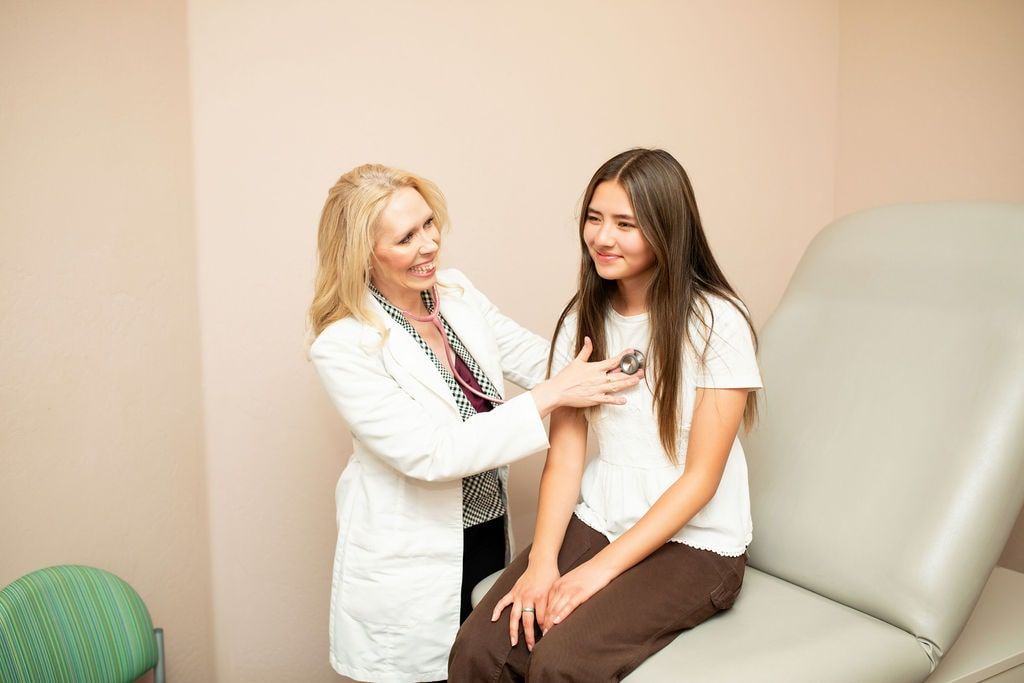 Tammy Frost examining a teenage patient in a medical exam room