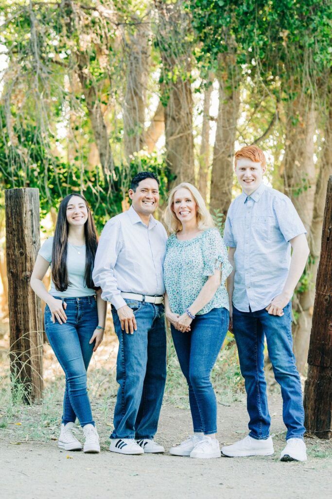 Tammy Frost standing with her family outdoors near a fence and trees