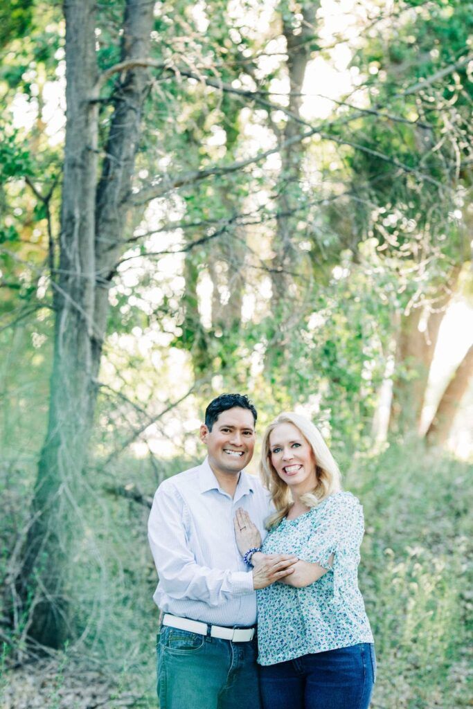 Tammy Frost standing with a man outdoors in a wooded area smiling together