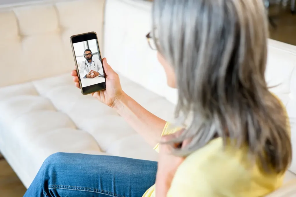 Senior woman experiencing benefits of having a primary care doctor through telehealth video call at home
