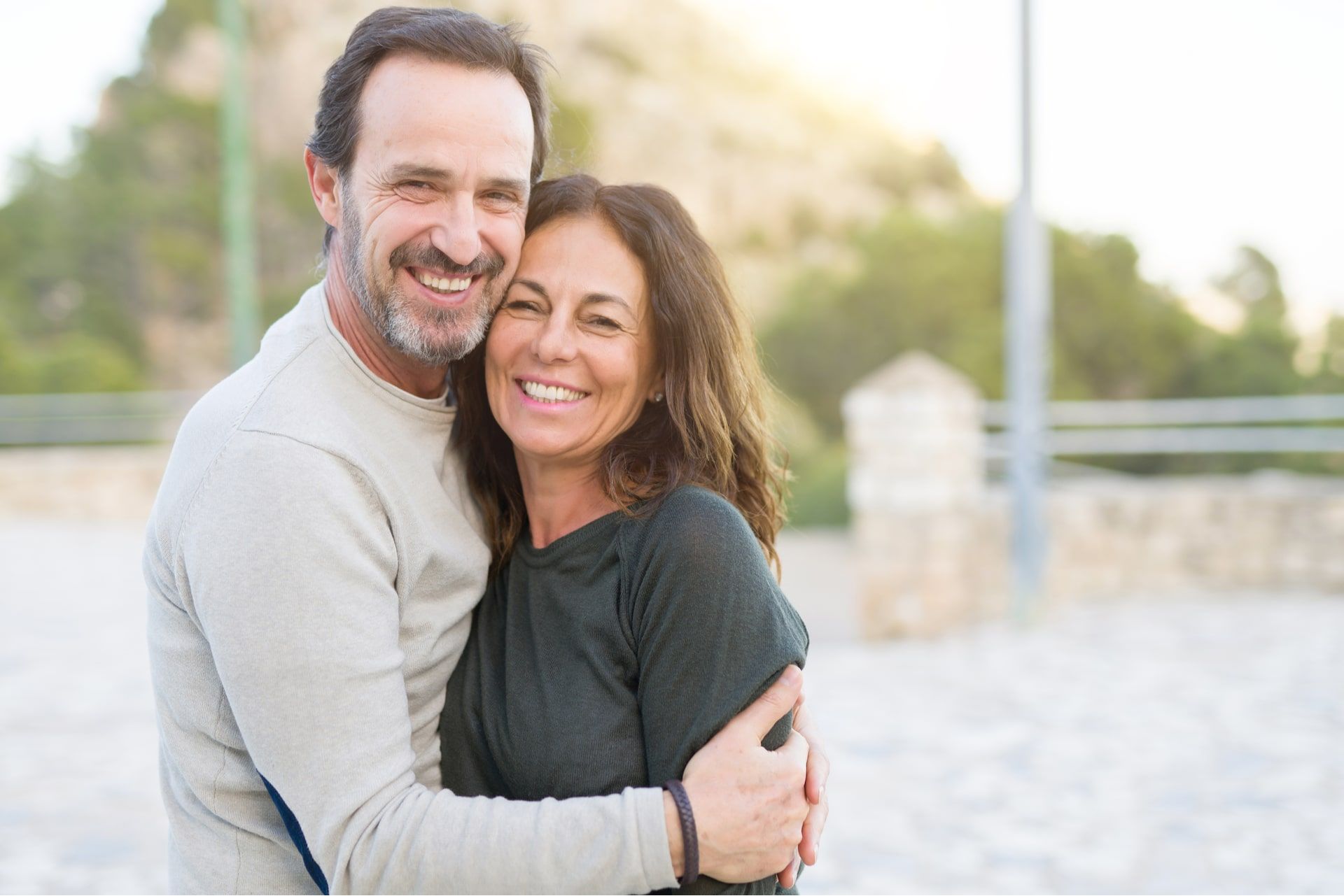 couple smiling and cuddling on a sunny day