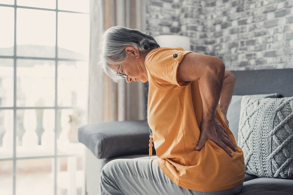 Unhappy mature woman feeling pain in back