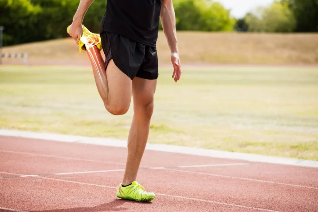 athlete man stretching on race track