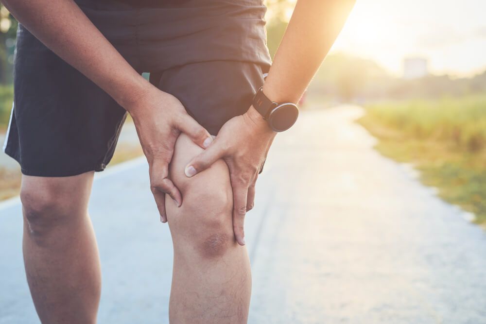 Man use hands hold on his knee while running