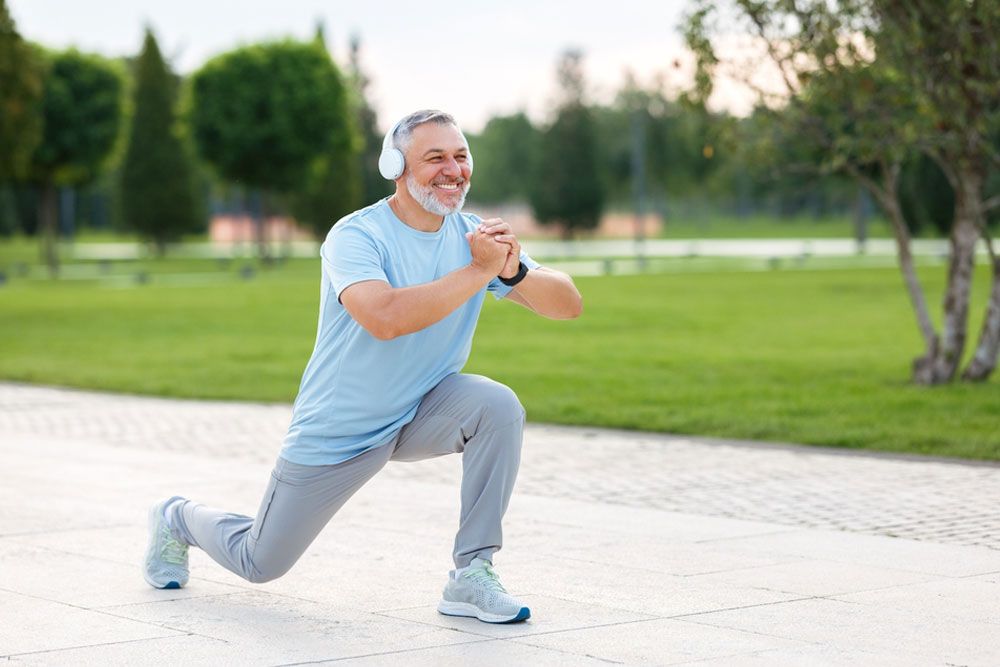 happy smiling retired sportsman in sportswear and headphones doing front squat