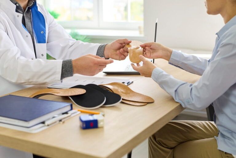 Prescription of custom insoles for flat feet correction and foot pain relief by male orthopedis