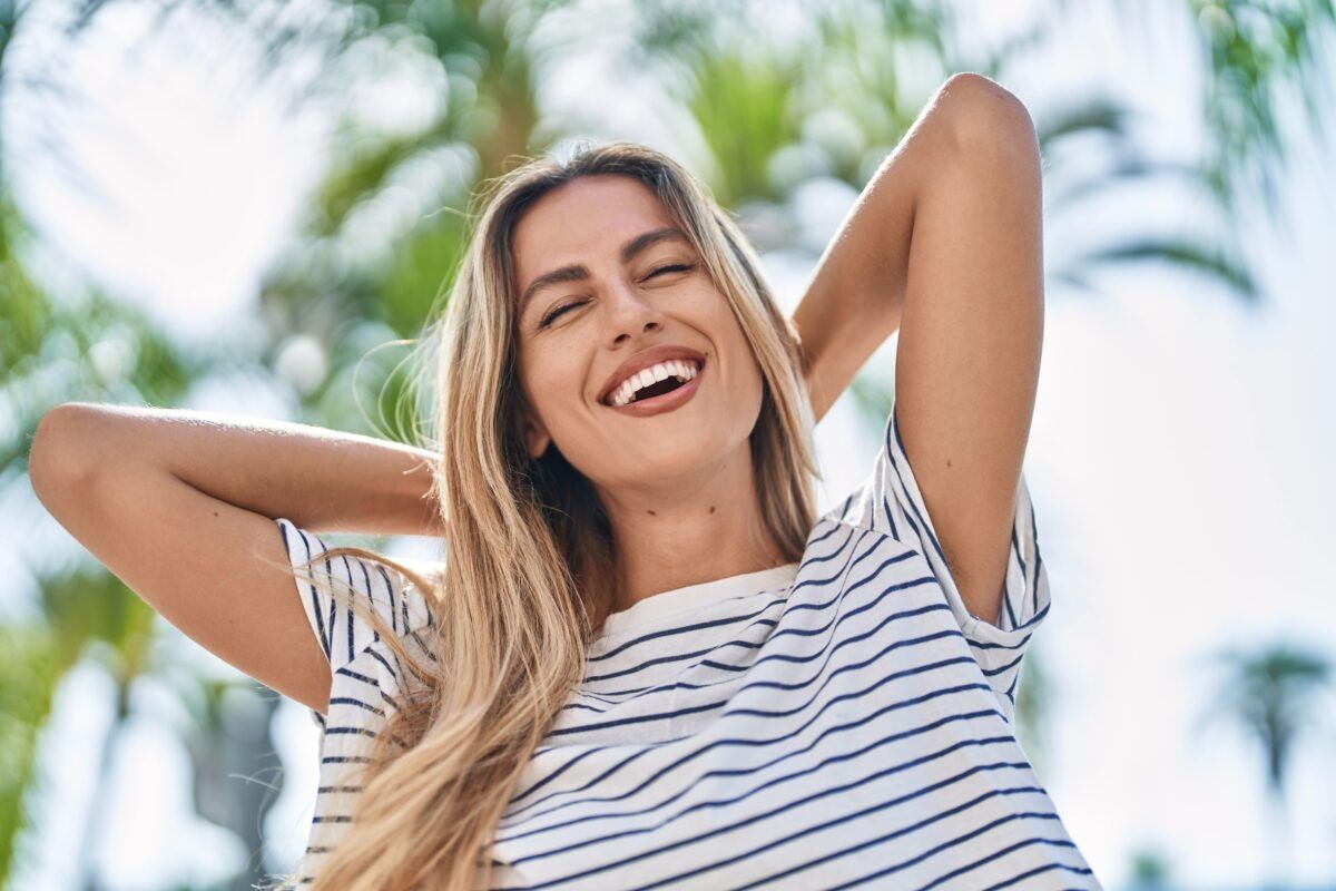 Young woman smiling confident relaxed with hands on head