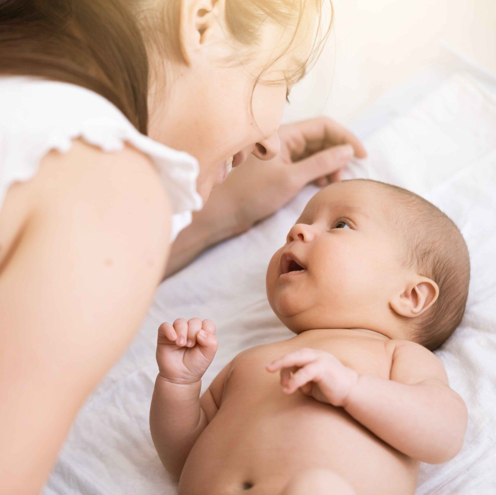 Mom talks and laughs with her newborn son at home