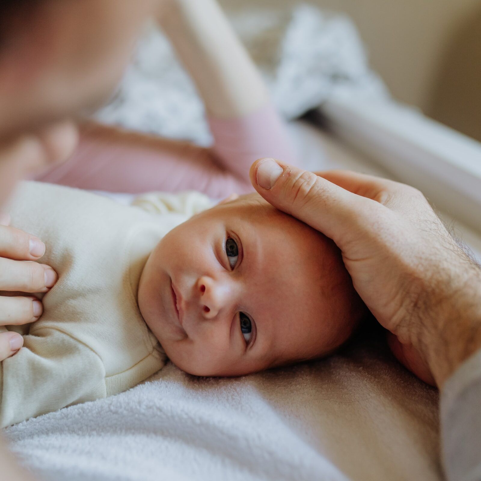 parents cuddling their newborn baby